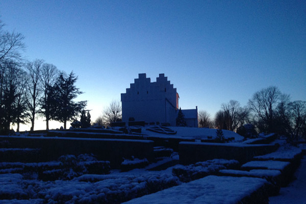 Hvalsø Kirke med sne og blå himmel