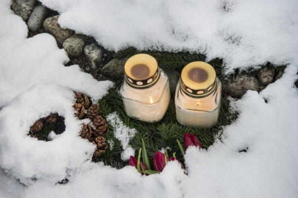 Billede af to lys i sne på gravsted
